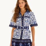Front view of the FARM Rio Blue Porcelain Garden linen mini shirt dress with matching circular-buckle belt and blue Azulejo tile print