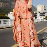 Side view of a model walking in the mocha FARM Rio floral maxi skirt, showcasing the cascading ruffled layers.