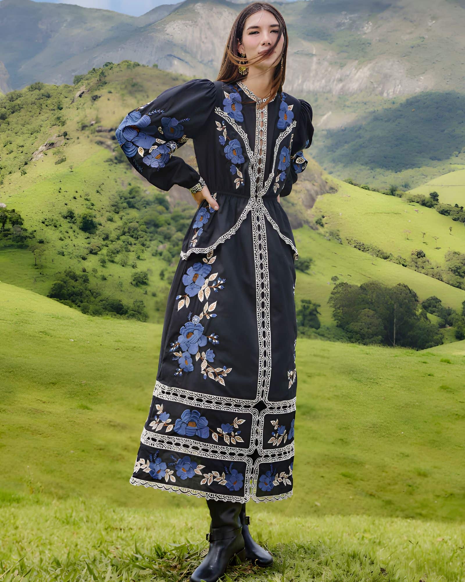 Full-length outdoor lifestyle view of a model in the FARM Rio Black Bold Flowers midi dress, paired with boots in a scenic green landscape.