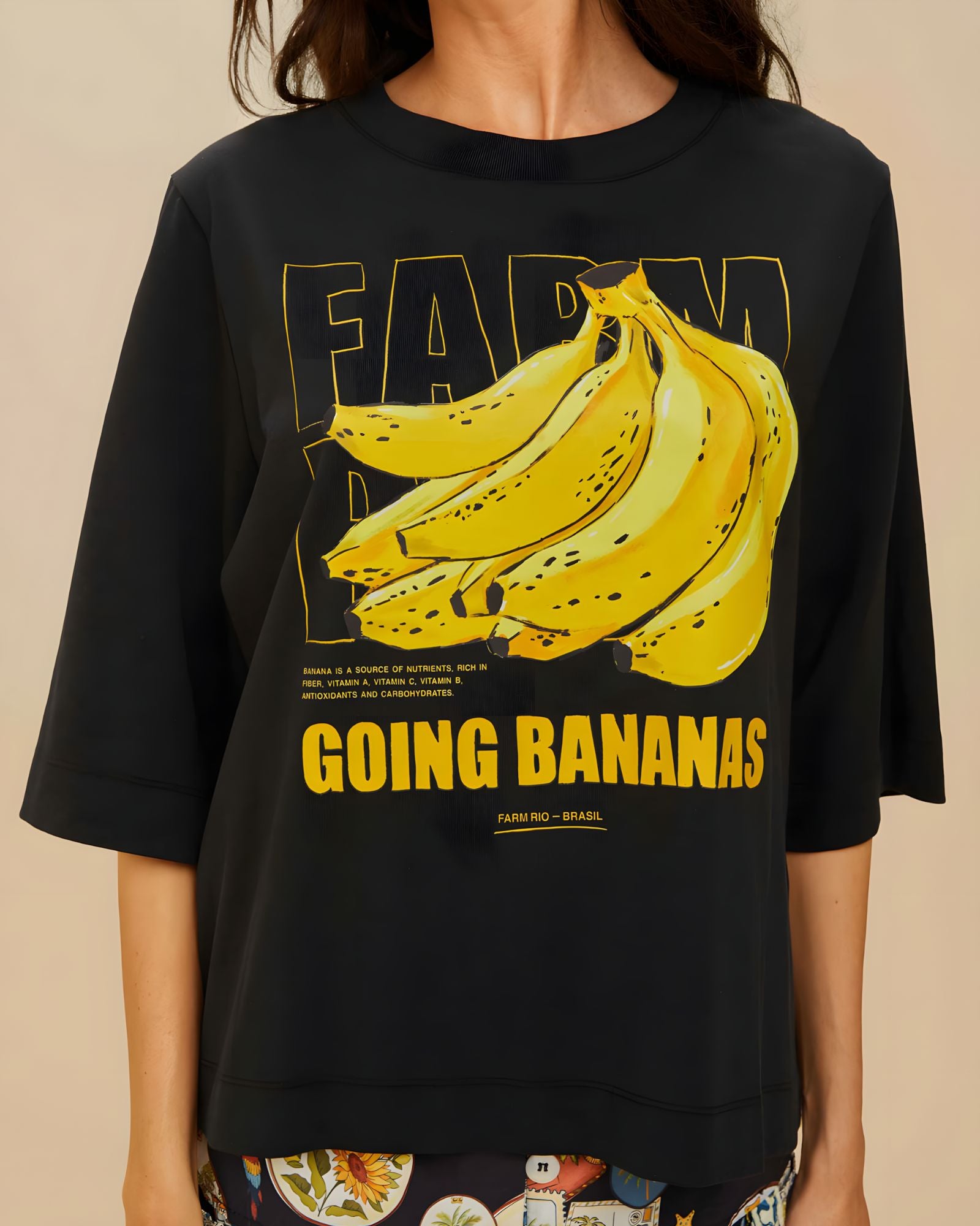 Detailed view of the yellow Going Bananas graphic print on the front of the black FARM Rio t-shirt