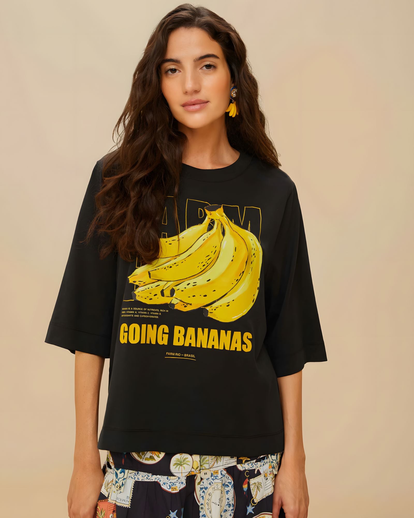 Model wearing FARM Rio black organic cotton t-shirt with Going Bananas graphic print, close-up front view