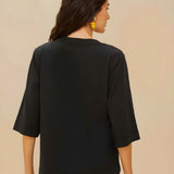 Back view of a model wearing the relaxed fit black FARM Rio organic cotton t-shirt