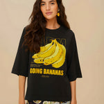 Model wearing FARM Rio black organic cotton t-shirt with Going Bananas graphic print, close-up front view