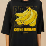 Detailed view of the yellow Going Bananas graphic print on the front of the black FARM Rio t-shirt
