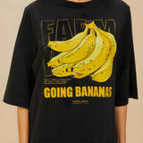 Detailed view of the yellow Going Bananas graphic print on the front of the black FARM Rio t-shirt