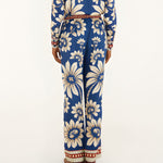 Back view of a model showcasing the fit and continuous blue botanical pattern of the FARM Rio wide-leg pajama pants.