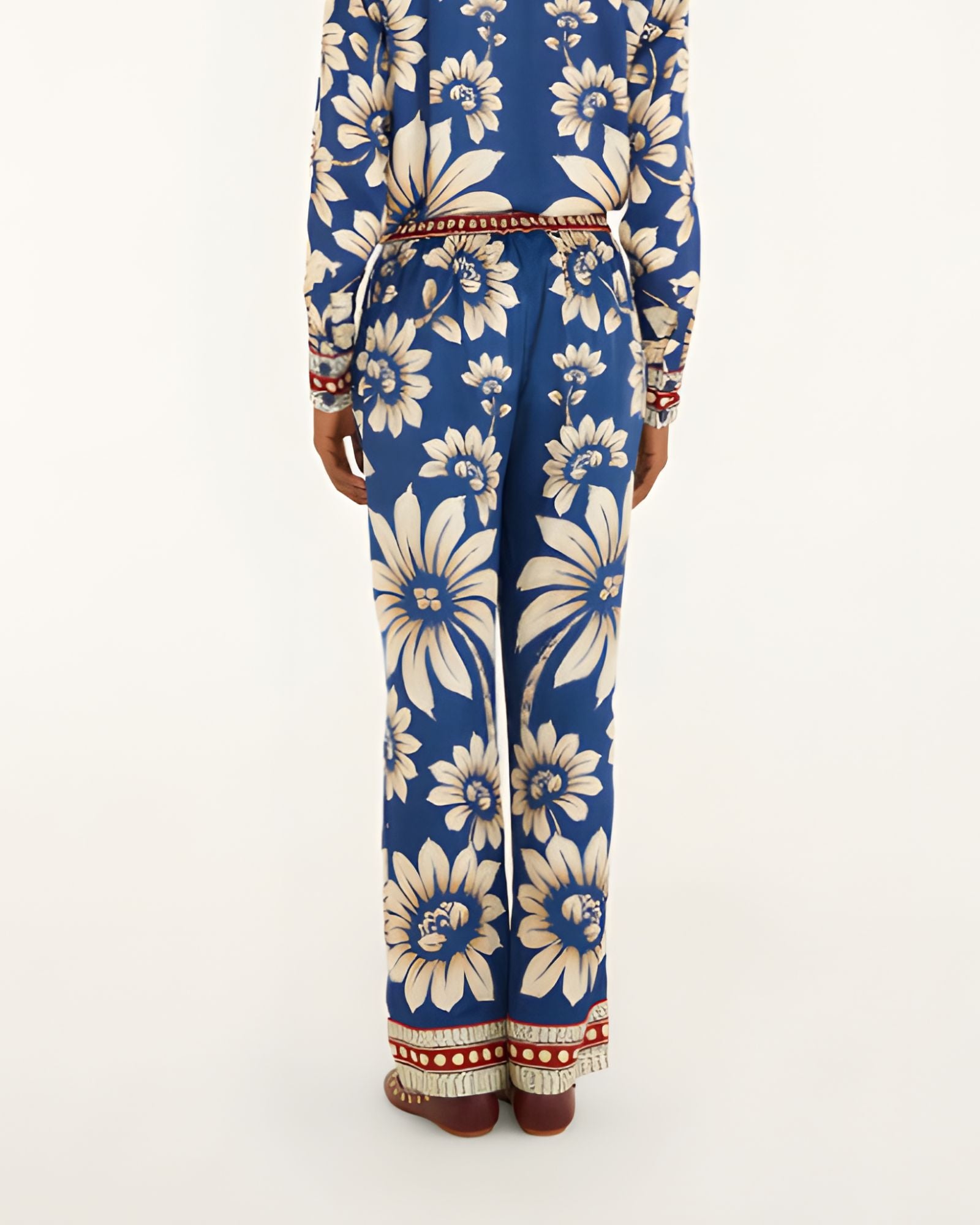 Back view of a model showcasing the fit and continuous blue botanical pattern of the FARM Rio wide-leg pajama pants.