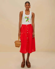 Woman wearing  white tank top with a parrot design by Farm Rio styled wth the Farm Rio red midi skirt .