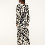 Back view of a model showcasing the continuous black and off-white botanical pattern across the Farm Rio long-sleeve maxi dress.