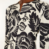 Close-up view of the Farm Rio Off-White Cashews and Birds maxi dress, highlighting the detailed slit V-neckline and artistic contrast print.