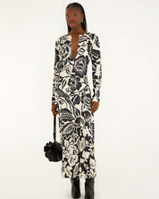 Full-length front view of a model in a studio wearing the Farm Rio Off-White Cashews and Birds viscose maxi dress with long sleeves and a bold graphic print.