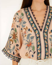 Close-up view of the V-neckline, lace trim, and floral print on the Farm Rio kimono sleeve bodysuit.