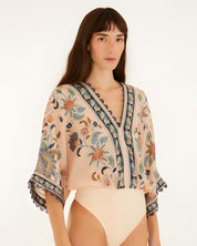 Studio view of the Farm Rio soft pink floral bodysuit highlighting the fit and bottom cut.