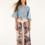 Model wearing FARM Rio soft pink pleated maxi skirt with sea-inspired scarf print, front view