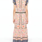Full-length back studio view of the Farm Rio maxi dress, highlighting the continuous floral pattern, smocked waist detailing, and ruffled shoulders.