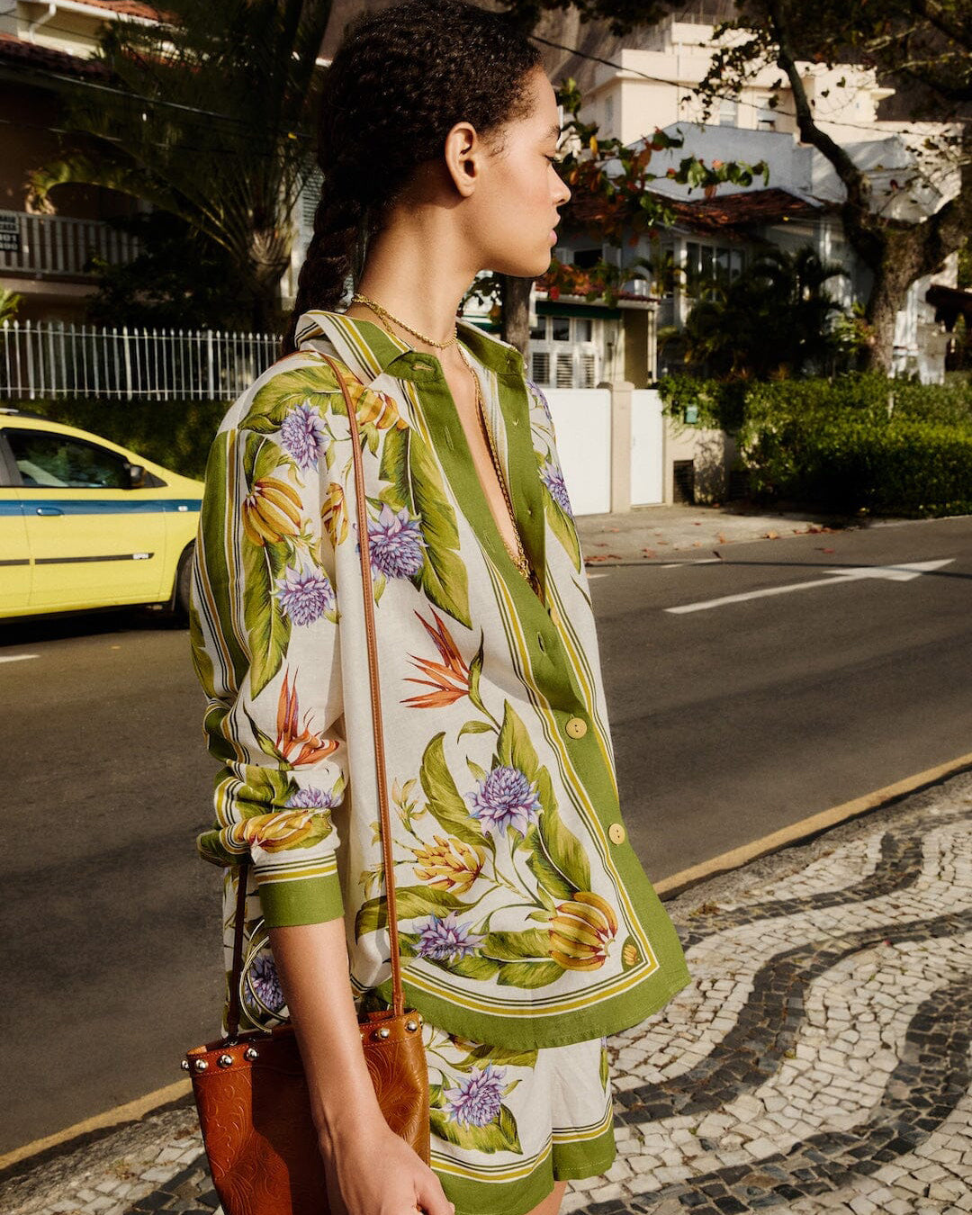 Woman wearing a floral dress with a street scene in the background