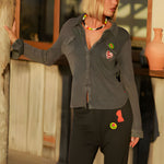 Full-length front view of a model styling the carbone straight-leg sweatpants with a matching button-down long-sleeve top.