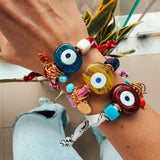 Detailed view of the 24k gold-plated hardware and glass eye on a Goupi textile bracelet.