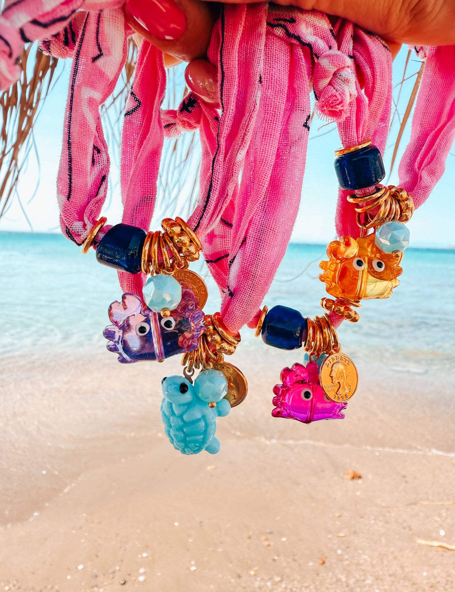 Colorful beaded bandana bracelets with cute crab charms on a beach