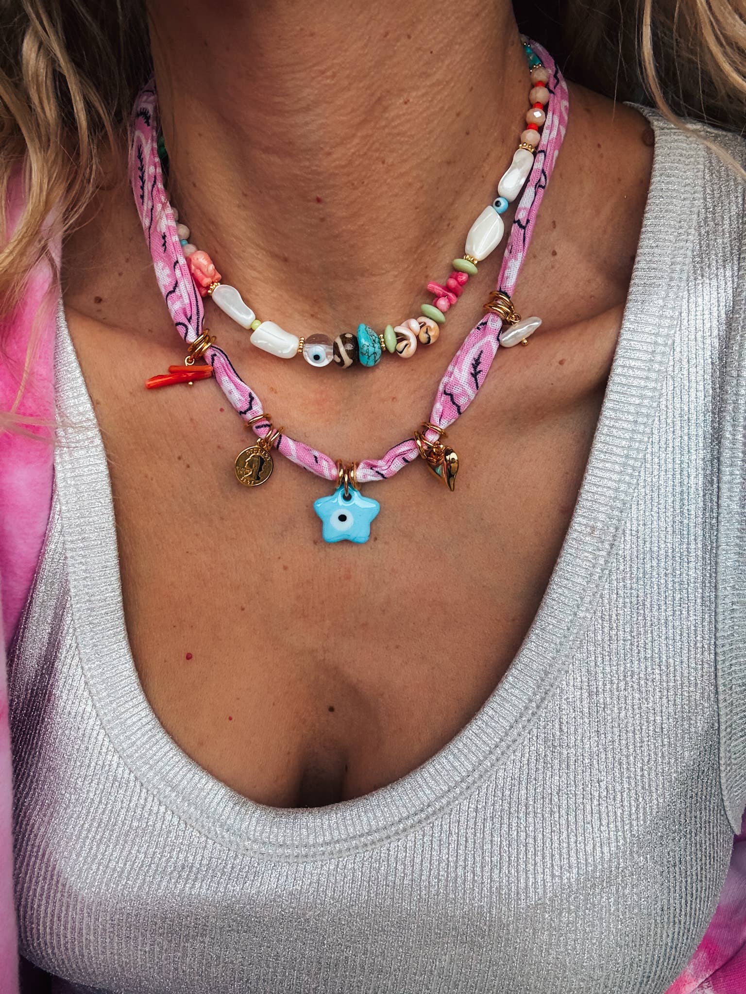 Close-up of the GOUPI pink bandana necklace with star charm, layered with the beaded necklace