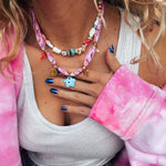 Woman wearing the GOUPI pink bandana necklace layered with the colourful beaded necklace