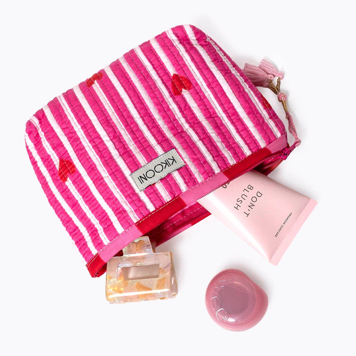 KIKOONI Love Edition pink mini pouch styled with skincare and beauty essentials