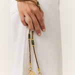 La Coque Française Izzie sage green phone chain worn crossbody with a white outfit