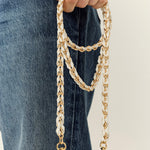 La Coque Française Lou white and gold braided phone chain held with jeans