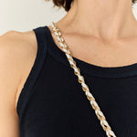 La Coque Française Lou braided phone chain in white and gold worn over a black top