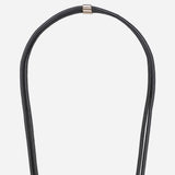 Detail of the gold-tone hardware and signature logo charm on the Nathan black vegan leather strap