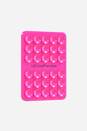 La Coque Française silicone suction phone grip pad in vibrant neon pink, featuring multiple small suction cups for hands-free mounting