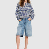 Full body shot of a woman wearing the Lanius blouse styled with denim shorts and sandals.