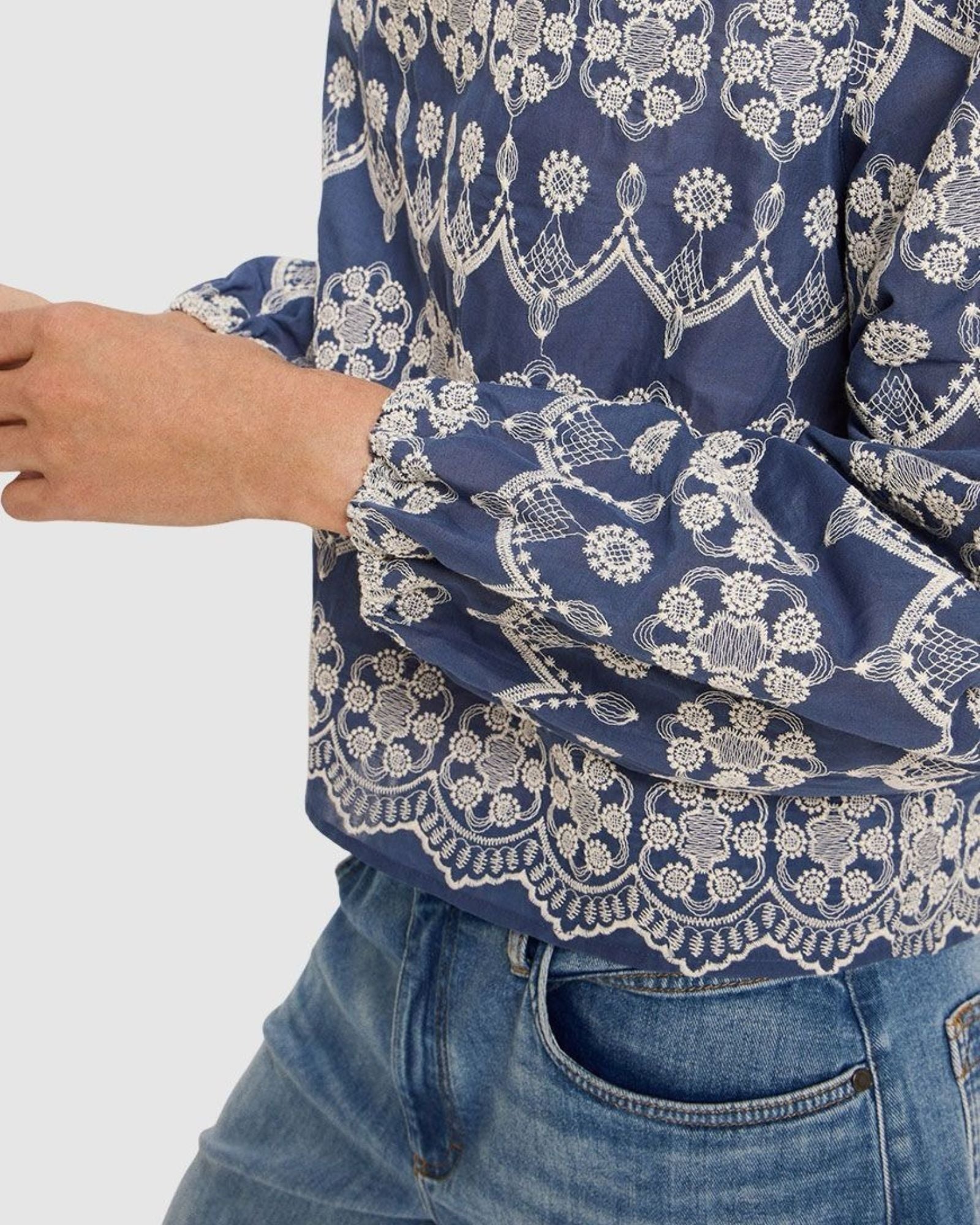 Blue patterned blouse with white lace details worn by a person