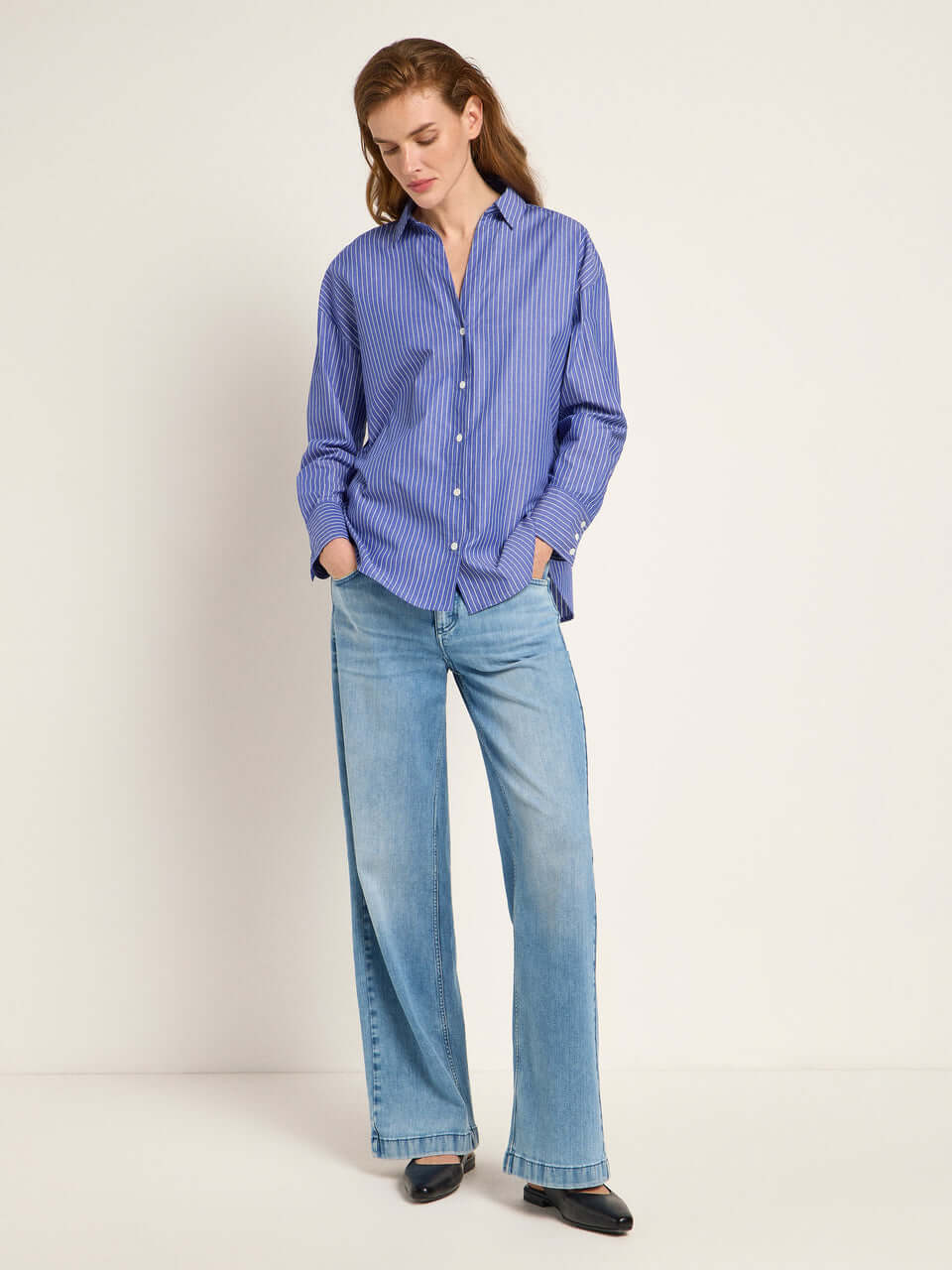 Woman wears the Lanius blue shirt from 99things.ch, styled with denim. 