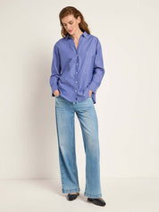 Woman wears the Lanius blue shirt from 99things.ch, styled with denim. 
