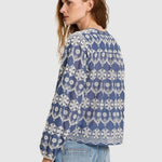 Woman wearing  Lanius blue blouse showing the continuous embroidery pattern