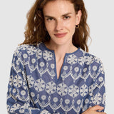 Close-up of the V-slit neckline and intricate white embroidery on the blue cotton.