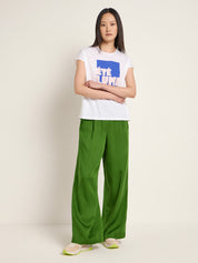 Woman wearing the Lanius ÉTÉ LUMINEUX organic cotton T-shirt styled with green pants for a fresh summer outfit