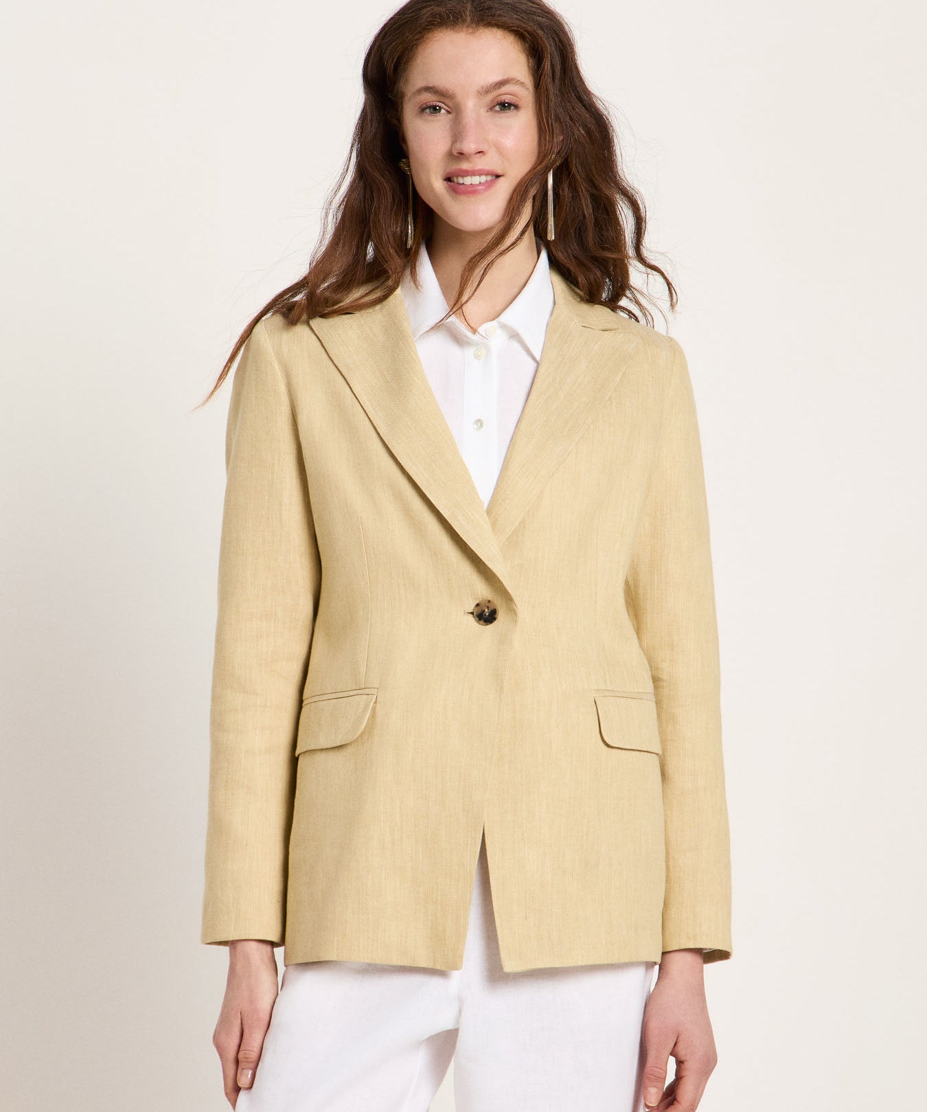 Woman wearing the relaxed-fit LANIUS khaki-creme linen blazer over a white shirt on a plain background