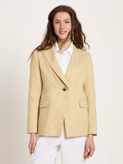 Woman wearing the relaxed-fit LANIUS khaki-creme linen blazer over a white shirt on a plain background