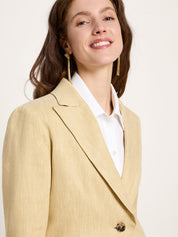 Side angle close-up focusing on the mid-width notched lapel structure, relaxed shoulder fit, and gold statement earrings.