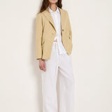 style inspiration showing the slightly longer length of the khaki-creme linen-blend blazer paired with wide-leg white linen trousers for a fluid silhouette.