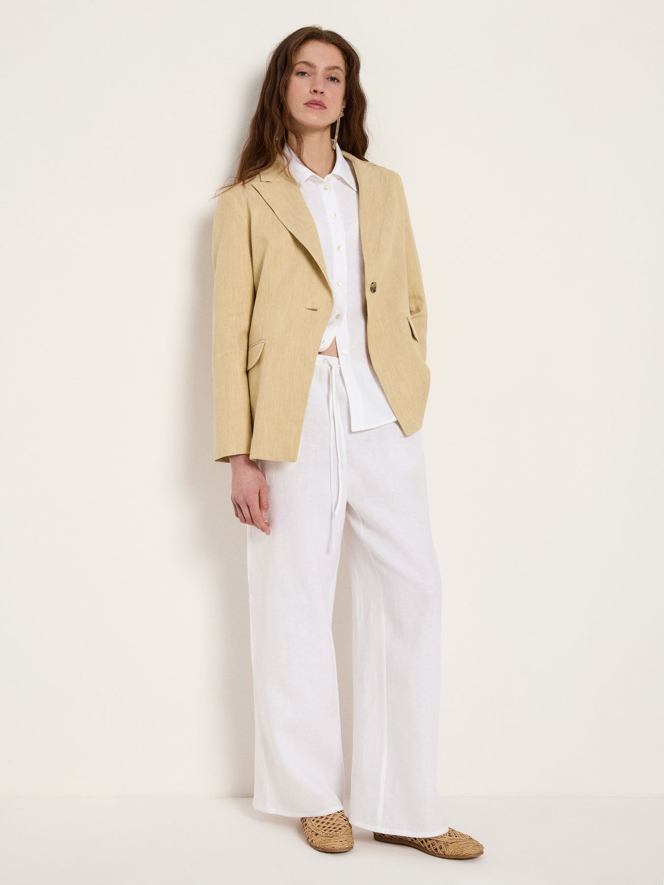 style inspiration showing the slightly longer length of the khaki-creme linen-blend blazer paired with wide-leg white linen trousers for a fluid silhouette.