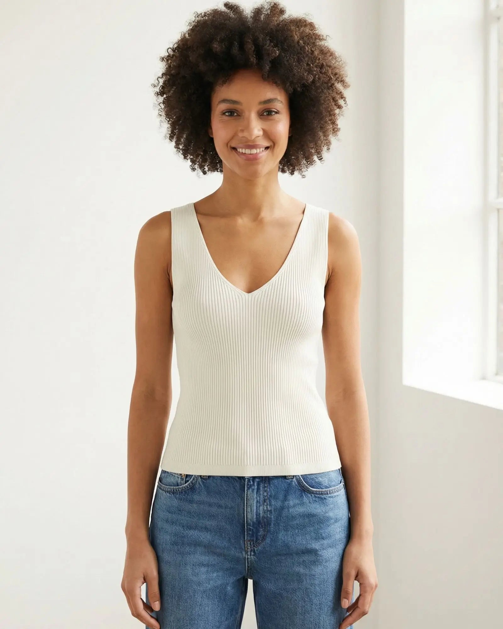 Model wearing a Lanius off-white rib knit organic cotton tank top with a V-neck, styled with blue jeans.