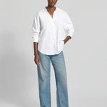 Woman wearing the Lanius oversized white organic cotton shirt paired with blue jeans.