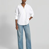 Woman wearing the Lanius oversized white organic cotton shirt paired with blue jeans.