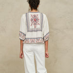 Rear view of a model showcasing the detailed geometric back embroidery on a Mabe Apparel ecru jacket.