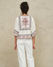 Rear view of a model showcasing the detailed geometric back embroidery on a Mabe Apparel ecru jacket.