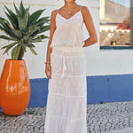 Model outdoors wearing a white embroidered Mabe Apparel camisole and white maxi skirt.