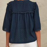 Back view of a woman wearing the Mabe Apparel navy blue embroidered blouse with wide sleeves.